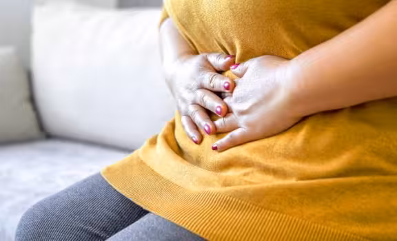 Image of patient holding stomach in pain